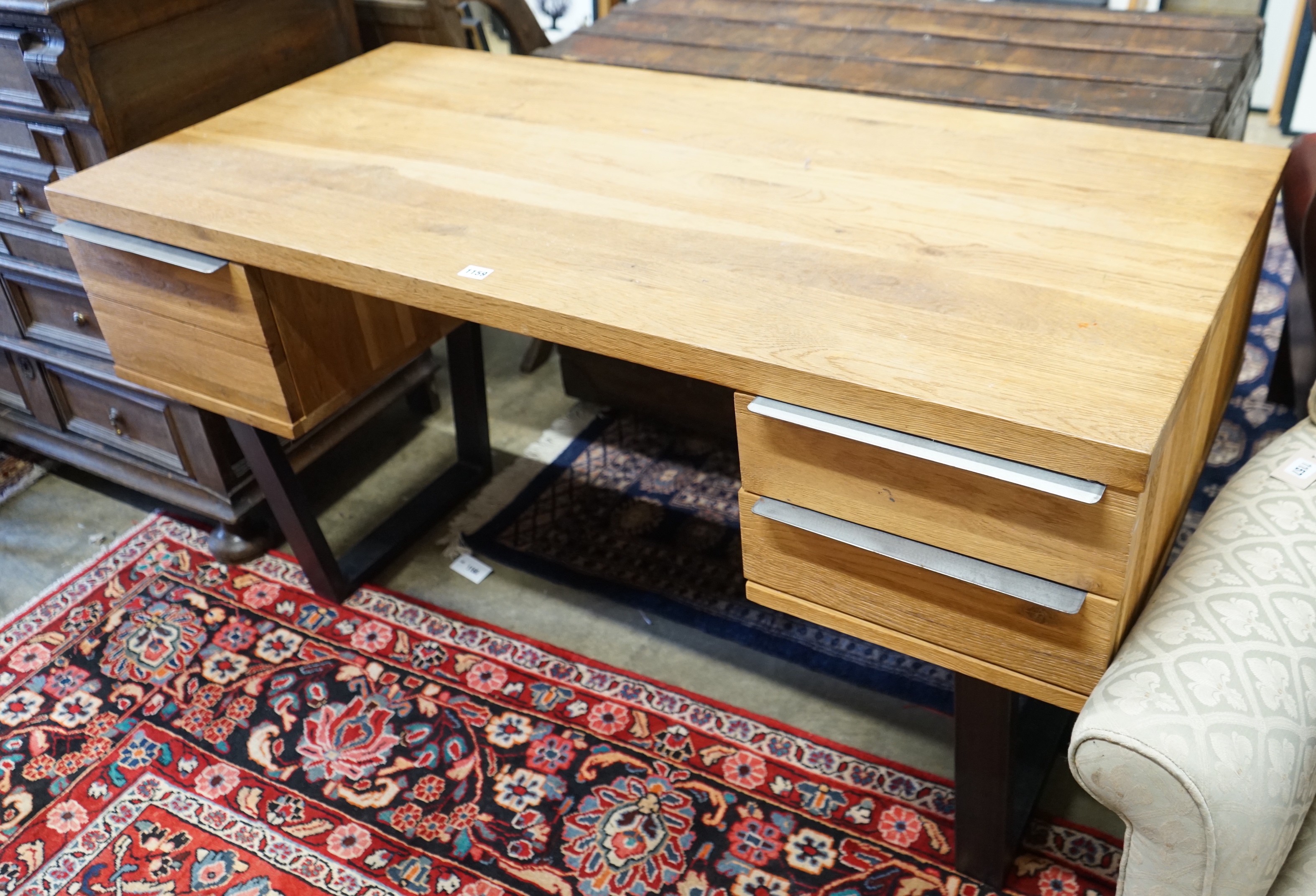 A contemporary oak and wrought iron kneehole desk, length 135cm, depth 67cm, height 76cm